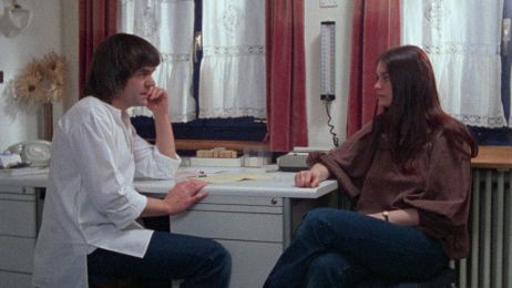 Eine Frau sitzt einem Arzt in einem Praxiszimmer gegen&uuml;ber und sie sprechen miteinander.