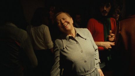 Die Schauspielerin Brigitte Mira schließt mit einem freudestrahlenden Lächeln die Augen und wird dabei von sanftem Licht erleuchtet. 