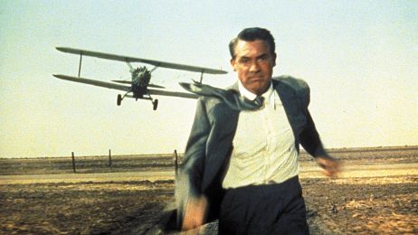 Cary Grant rennt vor einem Propellerflugzeug davon.