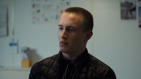 Ein junger Mann blickt nachdenklich und skeptisch nach vorn.