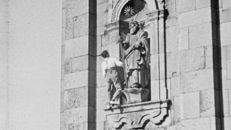 Ein Mann steht in einer Fassadeneinkerbung mit einer Statue.