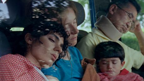 Drei Erwachsene und ein Kind sitzen schlafend in einem Auto.