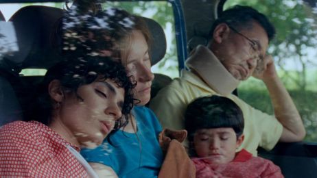 Drei Erwachsene und ein Kind sitzen schlafend in einem Auto.