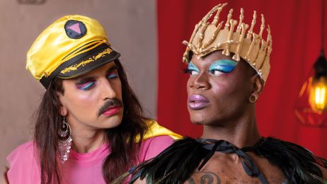 Zwei Personen mit farbenfroher Verkleidung und Make-up gucken sich an. 