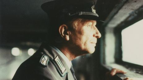 Ein Mann in Uniform schaut aus einem Fenster.