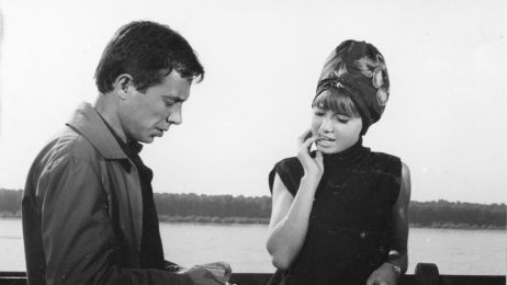 Ein schwarz wei&szlig; Bild aus den 80ern. Ein Mann und eine Frau stehen auf einem Steg vor einem See. Der Mann holt eine Zigarette raus.
