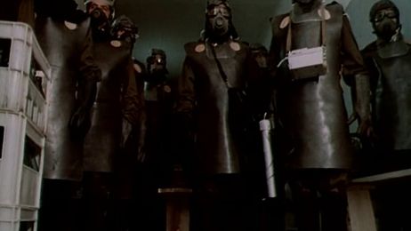 Eine Gruppe von mehreren Personen in Schutzanz&uuml;gen und Gasmasken