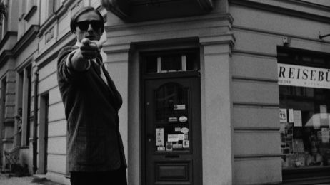 Ein junger Mann mit Sonnenbrille zeigt mit dem Finger direkt Richtung Betrachter.