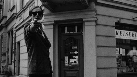 Ein junger Mann mit Sonnenbrille zeigt mit dem Finger direkt Richtung Betrachter.