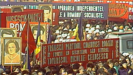 Eine gro&szlig;e Menschenmenge bei einer Demonstration mit roten Plakaten und Transparenten.