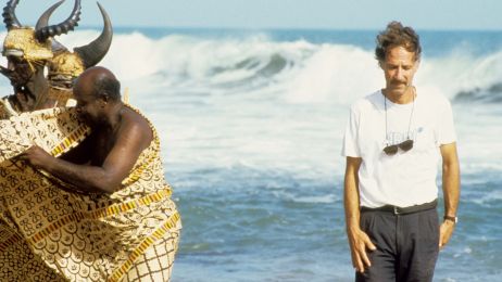 Regisseur Werner Herzog am Strand, auf der rechten Seite, zusammen mit Darstellern, die auf der linken Seite stehen.
