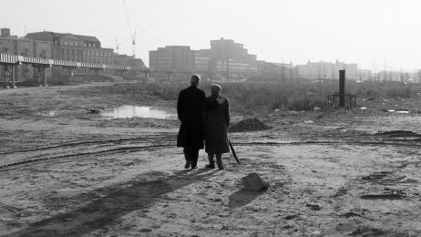 Zwei Personen stehen mit dem R&uuml;cken zur Kamera auf einem verlassenen Gel&auml;nde und gucken in die Ferne. Es ist eine schwarz-wei&szlig;e Fotografie.